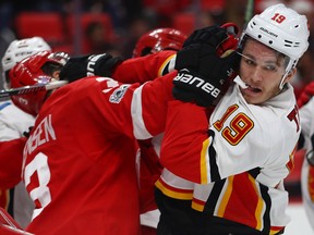 Matthew Tkachuk #19 of the Calgary Flames gets a glove to the face from Nick Jensen #3 of the Detroit Red Wings during the third period at Little Caesars Arena on November 15, 2017 in Detroit, Michigan.