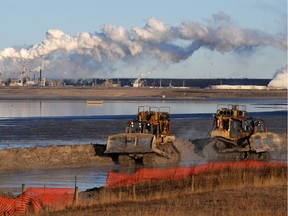 Workers use heavy machinery in the tailings pond at the Syncrude oil sands extraction facility in this file photo.