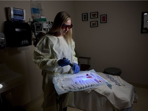 Nurse Lisa Bell uses a blue light in a exam room used by the Calgary Sexual Assault Response Team at the Sheldon Chumir Centre.