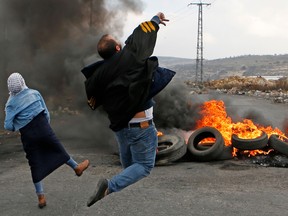 Palestinian protestors throw stones towards Israeli security forces during clashes following a demonstration in the West Bank city of Ramallah on December 13, 2017.