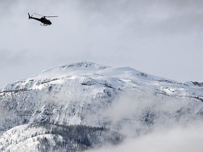 A search and rescue helicopter heads toward an avalanche site on  March 14, 2010 near Revelstoke, B.C.