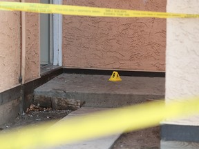 A crime scene marker is placed near broken glass and blood outside a unit in a Rundle condominium complex on Thursday December 7, 2017. The home on Rundlehorn Terrace N.E. was the scene of an early morning suspicious death. Gavin Young/Postmedia