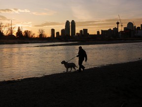 Edward Dounni walks his dog Peare at sunset along the Bow River in Calgary on a record setting temperature day, Saturday December 9, 2017. The high hit 15C breaking the record set in 1890.  Gavin Young/Postmedia