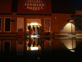 Water is reflected in the parking lot as workers pushed out water from Calgary Farmers Market after a serious water main break on Wednesday December 13, 2017. Gavin Young/Postmedia