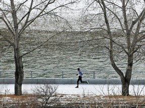 A noon hour runner cruises through an overnight dusting of snow along the Bow River on Monday December 18, 2017.