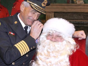 Calgary Fire Chief Steve Dongworth whispers to Santa Claus during the annual Calgary Firefighters Annual Christmas Party held at the Corral arena Sunday, December 17, 2017. Jim Wells/Postmedia