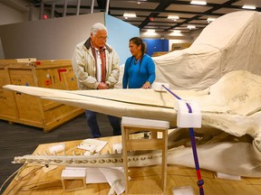 Casey Eagle Speaker (L) is joined by Maori representative Moana Parata, from the National museum of New Zealand, as organizers begin to set up the Whales/ Tohora touring exhibit at Telus Spark in Calgary on Friday, January 5, 2018. Eagle Speaker performed a Blackfoot blessing before the pair examined the skull of a female sperm whale skeleton which was uncrated.  Jim Wells/Postmedia