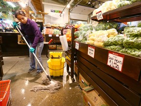 A worker mops and cleans the floor at the Calgary Farmers' Market in southwest Calgary on Thursday, December 14, 2017. A large water pipe burst late Wednesday afternoon, sending water throughout the popular market.