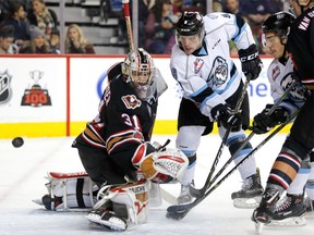 Kootenay Ice star Cameron Hausinger (right) tries to score on Calgary Hitmen net minder Nick Schneider in WHL action at the Scotiabank Saddledome in Calgary, on Sunday, December 17, 2017.