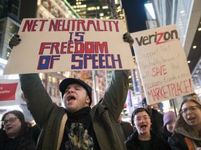 Demonstrators rally in support of net neutrality outside a Verizon store, Thursday, Dec. 7, 2017, in New York.
