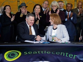Seattle Mayor Jenny Durkan, right, shakes hands with Los Angeles-based Oak View Group CEO Tim Leiweke after they signed an agreement to renovate KeyArena on Dec. 6, 2017