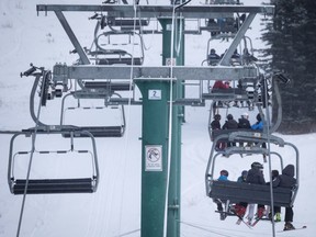 Skiers wait on the chair lift after a power failure shut down all operations at the women's World Cup downhill ski race at Lake Louise, Alta., Saturday, Dec. 2, 2017.