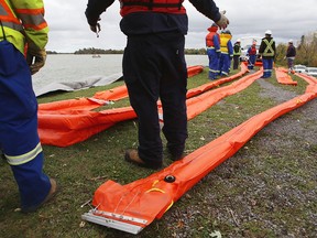 Workers with Enbridge Pipelines deploy inflatable booms during an oil spill response training exercise in Kingston, Ont., on Oct. 13, 2016.