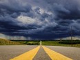 Storm clouds and the threat of hail build over a highway in southern Alberta near the town of Carstairs on Monday, July 4, 2016.