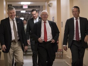 In this Dec. 5, 2017, photo, House Republicans, from left, Rep. Rob Woodall, R-Ga., Rep. Richard Hudson, R-N.C., Rep. Joe Barton, R-Texas, and Rep. Mark Sanford, R-S.C., arrive for a closed-door strategy session on Capitol Hill in Washington. Sounding a discordant note among the positive talk on the tax bill, a number of Republicans are delivering a blunt assessment, casting the bill as a boost to big corporations and the wealthy instead of the middle class. "Fundamentally if you look at the bulk of the bill, two-thirds of it, it's tied on the business side," Sanford said Tuesday as leaders in the House and Senate hailed their respective measures as an advantage for working Americans.