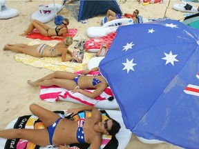 Beachgoers relax on inflatable thongs as Australia celebrates Australia Day at Bondi Beach in Sydney in 2011. Here in colder climes, the Calgary Kangaroos and Calgary Kookaburras Aussie-rules football clubs celebrate at Side Street Pub & Grill.