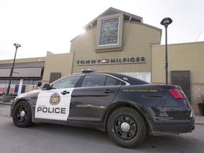 A police car sits outside of Tommy Hilfiger in the Westhills area of Calgary, Alta., on Tuesday, March 28, 2017. Lyle Aspinall/Postmedia Network