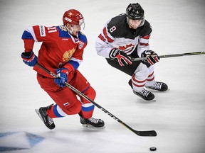 Russia's forward Sergey Kalinin (L) vies for the puck with Canada's forward Wojtek Wolski during the Channel One Cup of the Euro Hockey Tour ice hockey match between Canada and Russia in Moscow on December 16, 2017.  / AFP PHOTO / Alexander NEMENOVALEXANDER NEMENOV/AFP/Getty Images