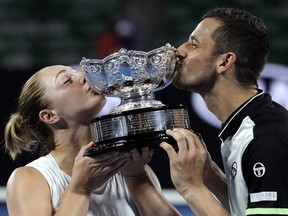 Canada's Gabriela Dabrowski, left, and Croatia's Mate Pavic kiss their trophy after defeating Hungary's Timea Babos and India's Rohan Bopanna in the mixed doubles final at the Australian Open tennis championships in Melbourne, Australia, Sunday, Jan. 28, 2018.