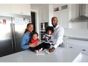 Elizabeth Archer holds 6 month old Matheo Roc, with three-year-old Malik Roc, and dad Jefferson Roc in their new home by Sterling Homes in Nolan Hill.