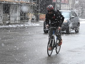 A bike courier dashes through snow in downtown Calgary.