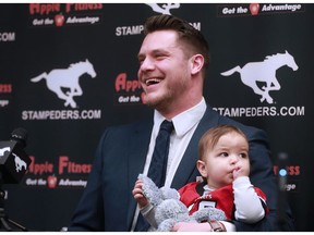 Calgary Stampeders linebacker Rob Cote holds his son Wynn as he announces his retirement at McMahon Stadium on Tuesday January 23, 2018.