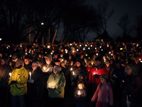 Hundreds of people hold candles in support and memory of Aubrey Berry, 4, and her sister Chloe, 6, during a vigil held at Willows Beach in Oak Bay, B.C., on Saturday, December 30, 2017.