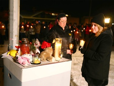 Alberta MLA Deb Drever (R) looks at a memorial as she joins other supporters during a candlelight vigil in northwest Calgary on Wednesday, January 3, 2018 for the baby found dead on Christmas Eve. Abouth 100 or more Calgarians and made respects for the newborn. Police and still looking for the mother and any other clues in the case. Jim Wells/Postmedia