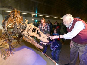Wayne Haglund, Professor Emeritus and the driving force behind Cretaceous Lands exhibit, shares a laugh with a young visitor at Mount Royal University. Three fossil displays were unveiled at the university's East gate on Jan. 11, 2018.