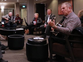 Rev. Bruce Sheasby, second from right, sings with members of his congregation while waiting to testify at a federal Trademarks Opposition Board hearing at the Delta Calgary South hotel on Monday.