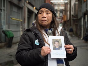 Janet Charlie holds a photo of her late son, Tyler Francis Charlie, who died at the age of 26 due to a fentanyl overdose. She is photographed in the Downtown Eastside of Vancouver.