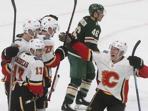 Flames Dougie Hamilton, left, is congratulated on his winning goal in overtime against the Minnesota Wild on Jan. 9, 2018.