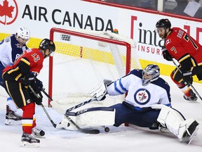 The Calgary Flames' Johnny Gaudreau comes close on this shot on Winnipeg Jets goaltender Connor Hellebuyck during NHL action at the Scotiabank Saddleome in Calgary on Saturday January 20, 2018.