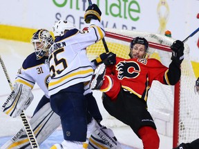 The Buffalo Sabres' Rasmus Ristolainen knocks over the Calgary Flames' Troy Brouwer during NHL action against the Calgary Flames at the Scotiabank Saddledome on Calgary on Monday. The Sabres won 2-1 in overtime. Photo by Gavin Young/Postmedia.