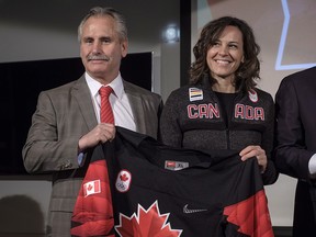 Head coach Hockey Canada Willie Desjardins and Team Canada chef de mission Isabelle Charest hold a jersey after announcing Canada's National Men's Team roster in Calgary on Jan. 11, 2018.