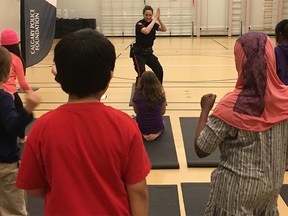 Const. Lisa Collier leading a yoga class before school even begins at Patrick Airlie Elementary School in Forest Lawn. Photo credit goes to Kerri Firza, CPS