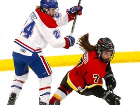Calgary Inferno star Brittany Esposito is checked by Les Canadiennes De Montreal's Ann-Sophie Bettez in first-period action at WinSport in Calgary, Alta., on Sunday, January 7, 2018.