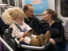 A toddler plays with a mobile phone while riding in a New York subway. Two major Apple investors have urged the iPhone maker to take action to curb growing smartphone use among children, highlighting growing concern about the effects of gadgets and social media on youngsters.