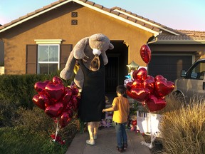 Neighbor Liza Tozier, and her son, Avery Sanchez, 6, drop off his large "Teddy" as a gift for the children who lived on a home where police arrested a couple on Sunday accused of holding 13 children captive in Perris, Calif., Thursday, Jan. 18, 2018. The parents of 13 children and young adults have pleaded not guilty in a California court to numerous charges that they tortured and abused the siblings for years. David and Louise Turpin were each ordered held on $12 million bail after entering their pleas Thursday and were scheduled to return to court on Feb. 23.