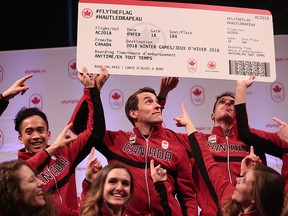 Denny Morrison, centre, surrounded by other members of the Canada's Olympic long-track speedskating team, holds aloft a plane ticket to South Korea. Speed Skating Canada unveiled its long-track team in Calgary on Jan. 10, 2018.