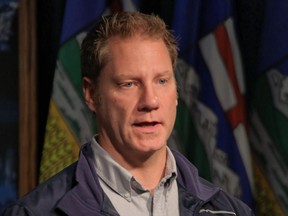 Rick Fraser speaks to reporters in Calgary in a 2014 file photo when he served as associate minister for regional recovery and reconstruction for High River.