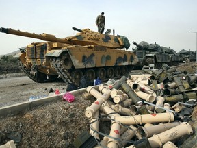Turkish army soldiers prepare their tanks next to empty shells at a staging area in the outskirts of the village of Sugedigi, Turkey, on the border with Syria.