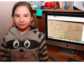 Jacquie Chmilar, 10, poses next to a photograph of one of the messages she cast into the Atlantic during a July trip to Newfoundland on January 16, 2018. The message was one of two found on a beach in Cornwall, U.K. earlier this month.