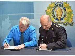 Trevor Tychkowsky, left, president of the Alberta Provincial Rural Crime Watch, and RCMP Deputy Commissioner Todd Shean sign a memorandum of understanding outlining the roles each organization will play in keeping rural communities safe in the province, at K Division headquarters in Edmonton on Thursday, Feb. 5, 2018.