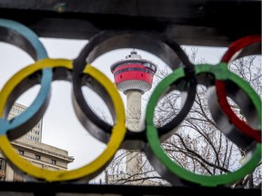 The Calgary Tower is seen with Olympic rings built into railing at Olympic Plaza in downtown Calgary, Alta., on Monday, March 20, 2017. The city is considering another Winter Olympics bid. Lyle Aspinall/Postmedia Network