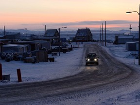 The sun rises as a car drives along a road in Iqaluit, Nunavut on Wednesday, December 10, 2014. Canada's Arctic is falling far behind northern regions in other parts of the world, says a study from an international affairs think-tank.
