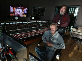 Don Schmid, seated, and Jay Semko with The Northern Pikes were photographed with the historic Trident A Range console in a recording studio at Studio Bell. The four members of the band were spending 10 days recording their new album in the studio.