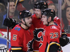 The Calgary Flames' Mark Giordano and Sean Monahan congratulate Dougie Hamilton after Hamilton scored on the the Florida Panthers during NHL action in Calgary on Saturday February 17, 2018. Gavin Young/Postmedia