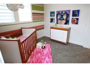 A bedroom in the 2013 Stampede Rotary Dream Home by Homes by Avi, where colourful art pieces of dogs were used to elevate the space.