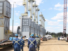 Employees at the Cenovus Christina Lake oilsands facility, located south of Fort McMurray, walk past gravity separators as they begin their shift in this May 2012 file photo.